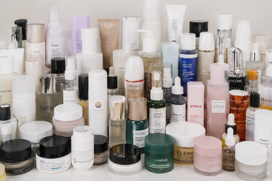 A photo with a multitude of skincare products cluttered on a countertop.