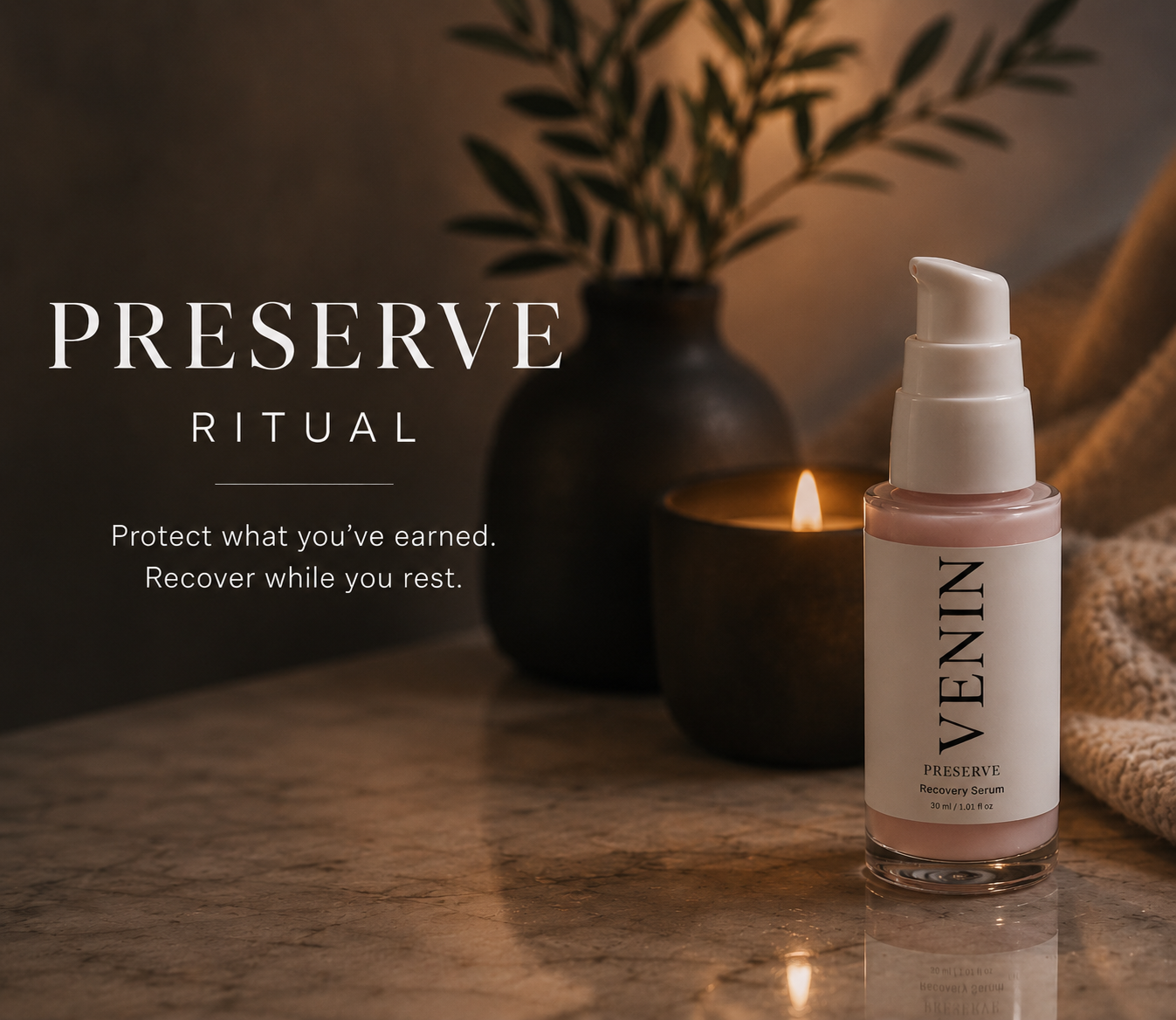 A bottle of VENIN Preserve Ritual stands on a marble surface beside a lit candle, a dark vase with leaves, and a soft beige textile. The bottle has a white pump and a white label with black text, containing a pale pink cream.