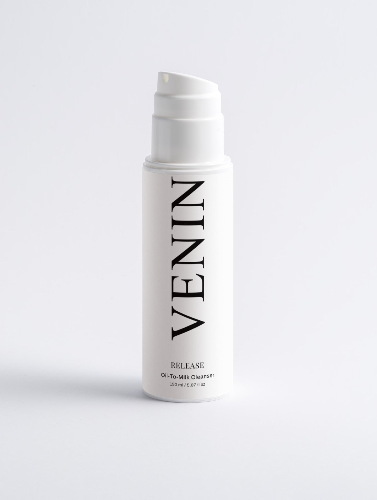 A white pump bottle of VENIN Release Oil-To-Milk Cleanser with black text, centered on a light gray background.