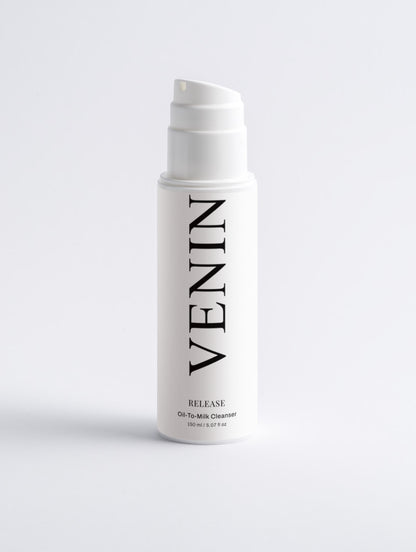A white pump bottle of VENIN Release Oil-To-Milk Cleanser with black text, centered on a light gray background.