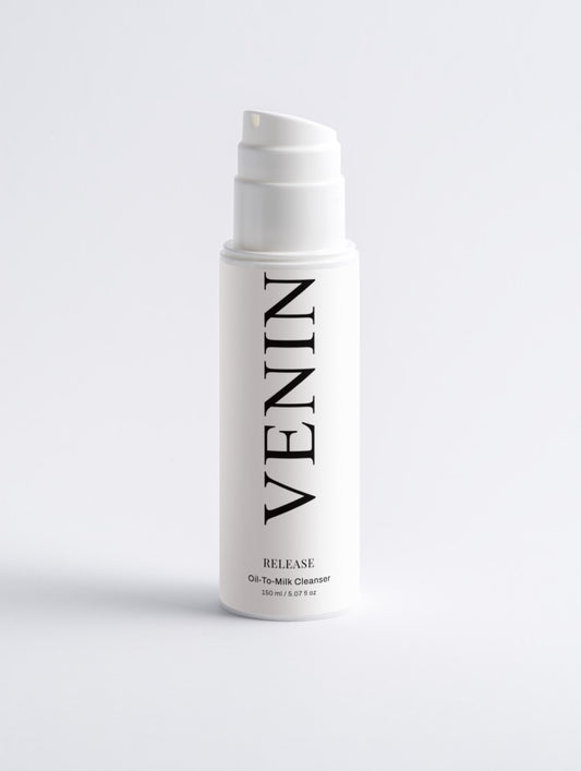 A white pump bottle of VENIN Release Oil-To-Milk Cleanser with black text, centered on a light gray background.